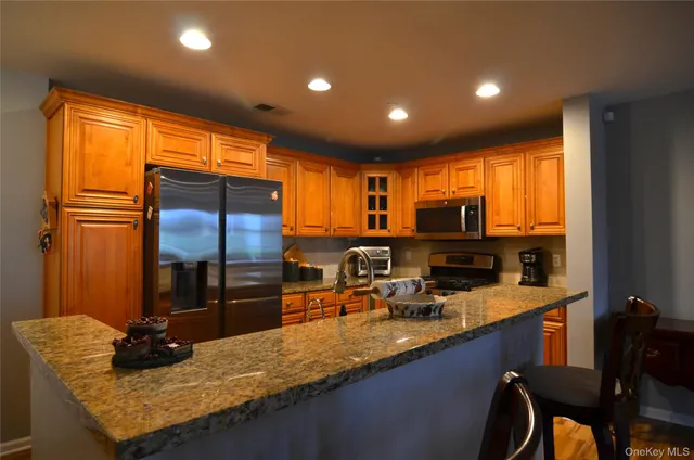 a kitchen with granite countertop a sink and a refrigerator