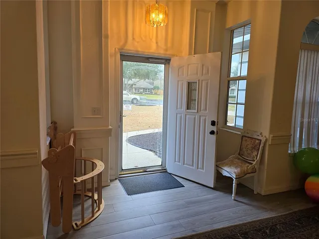 a view of a hallway with wooden floor and entryway