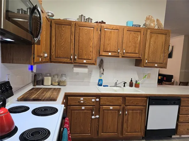 a kitchen with stainless steel appliances a stove refrigerator sink and cabinets