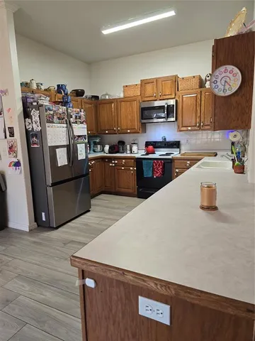a kitchen with stainless steel appliances granite countertop a sink dishwasher and cabinets with wooden floor