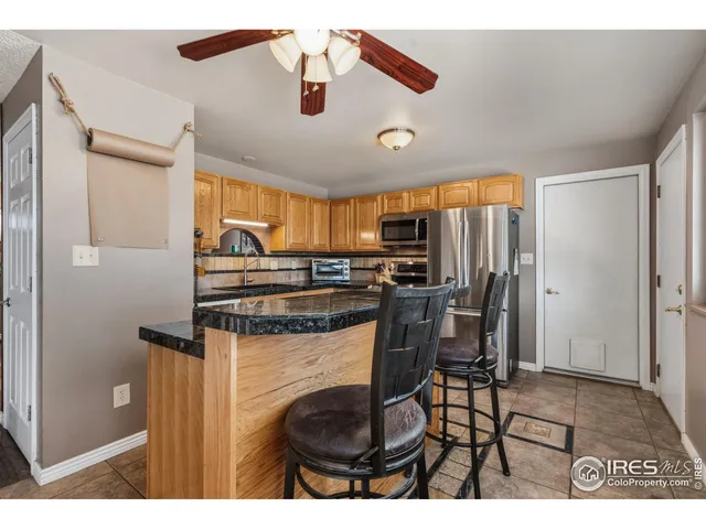 a kitchen with stainless steel appliances kitchen island granite countertop a refrigerator and microwave