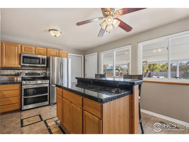 a kitchen with stainless steel appliances granite countertop a sink a stove and a refrigerator