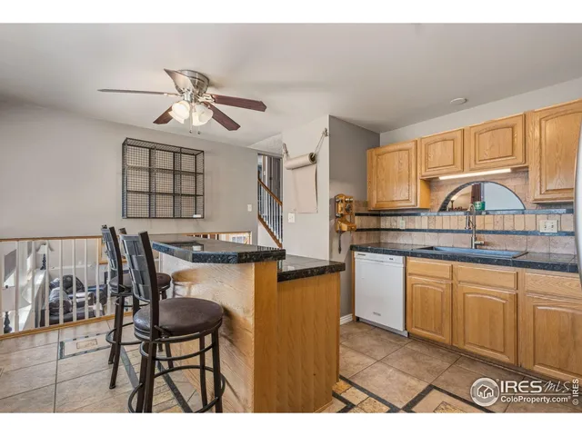 a kitchen with stainless steel appliances granite countertop a sink a stove a refrigerator cabinets and dining table