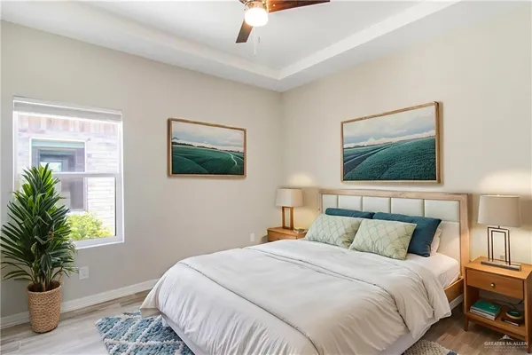 a bedroom with a large bed and a potted plant