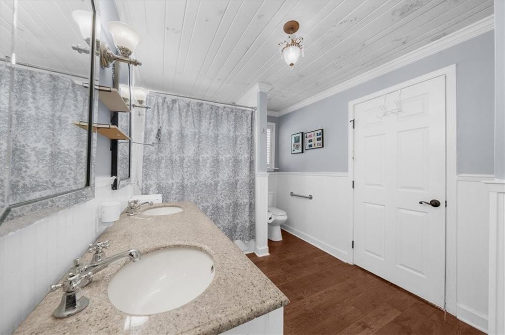 6551 Bermuda Lane Flowery Branch, GA 30542 - Photo 20 of 43 a bathroom with a granite countertop sink a mirror and shower