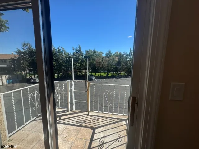 a view of a balcony with floor to ceiling window wooden floor and fence