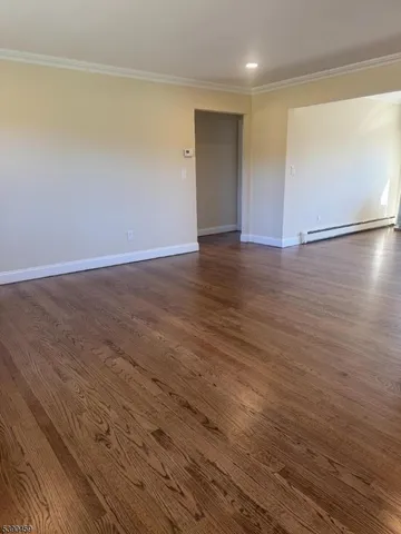 a view of an empty room with wooden floor