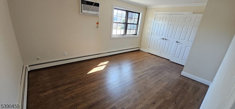 1240 Van Houten Avenue, Unit 7A Clifton, NJ 07013 - Photo 8 of 14 an empty room with wooden floor and windows