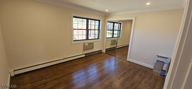 1240 Van Houten Avenue, Unit 7A Clifton, NJ 07013 - Photo 9 of 14 an empty room with wooden floor and windows