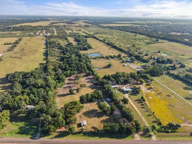 an aerial view of ocean and residential houses with outdoor space