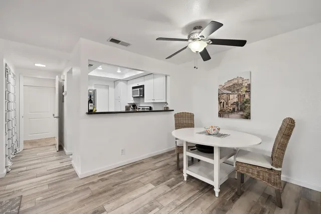 a view of a dining room with furniture and a chandelier fan