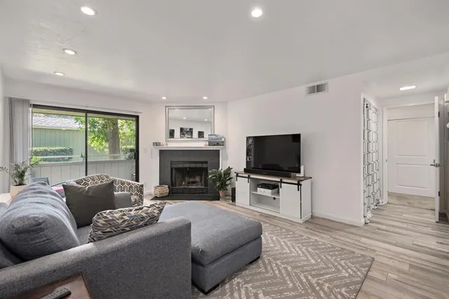 a living room with furniture a fireplace and a flat screen tv
