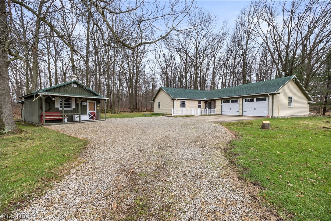 11923 Green Road Wakeman, OH 44889 - Photo 3 of 45 View of front of home with driveway, a front lawn, covered porch, and a garage