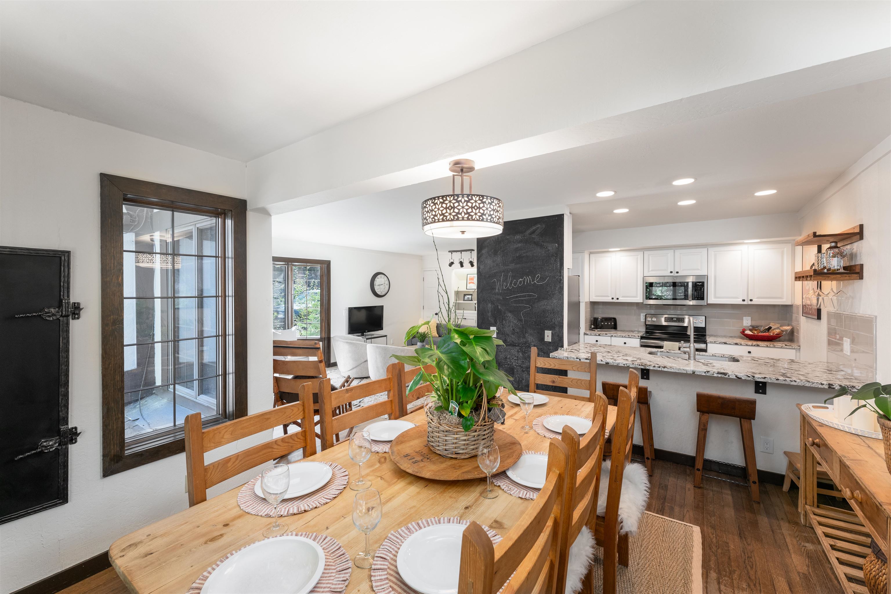 227 Olympic Vly Road, Unit 27 Olympic Valley, CA 96146 - Photo 4 of 21 a dining room with wooden floor a chandelier a wooden table and chairs