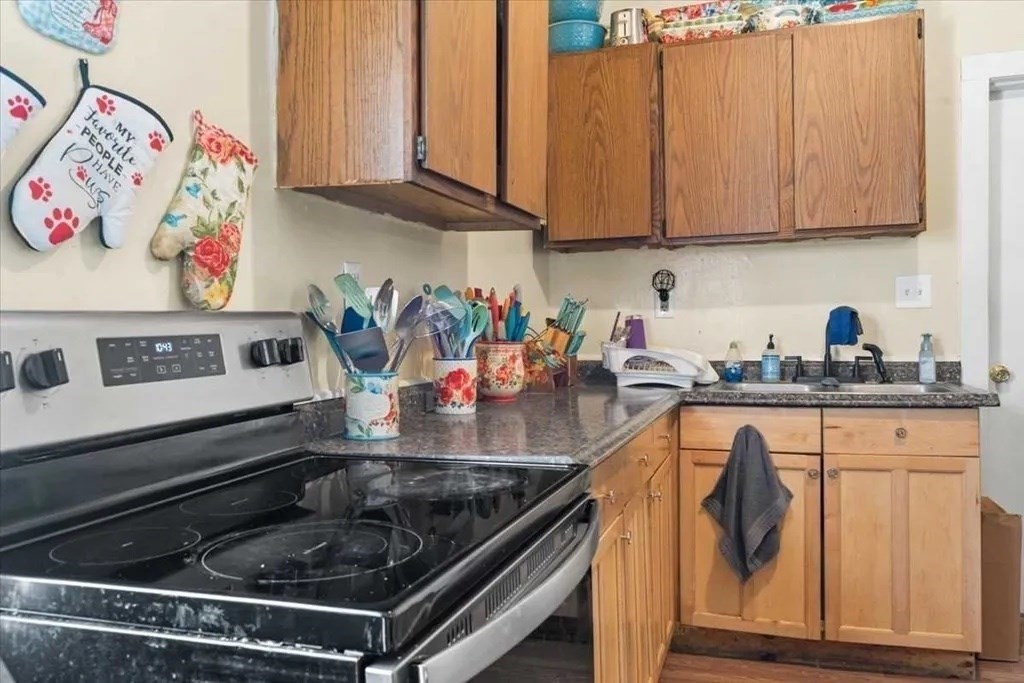83 West Main Street Orange, MA 01364 - Photo 10 of 12 a kitchen with stainless steel appliances granite countertop a sink and cabinets