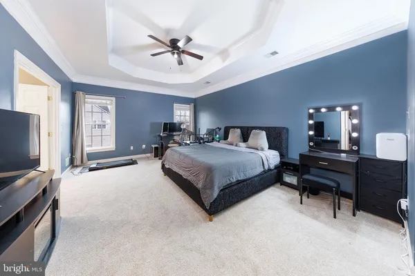 a bedroom with a bed a chair and a large window