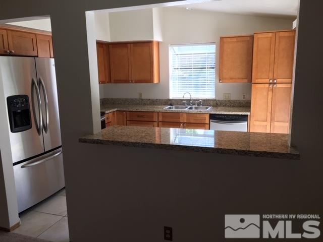 6066 Warm River Road Reno, NV 89523 - Photo 3 of 8 a kitchen with granite countertop a refrigerator and a sink