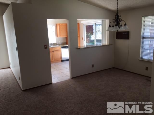 6066 Warm River Road Reno, NV 89523 - Photo 6 of 8 a kitchen with kitchen island a counter top space appliances and a window