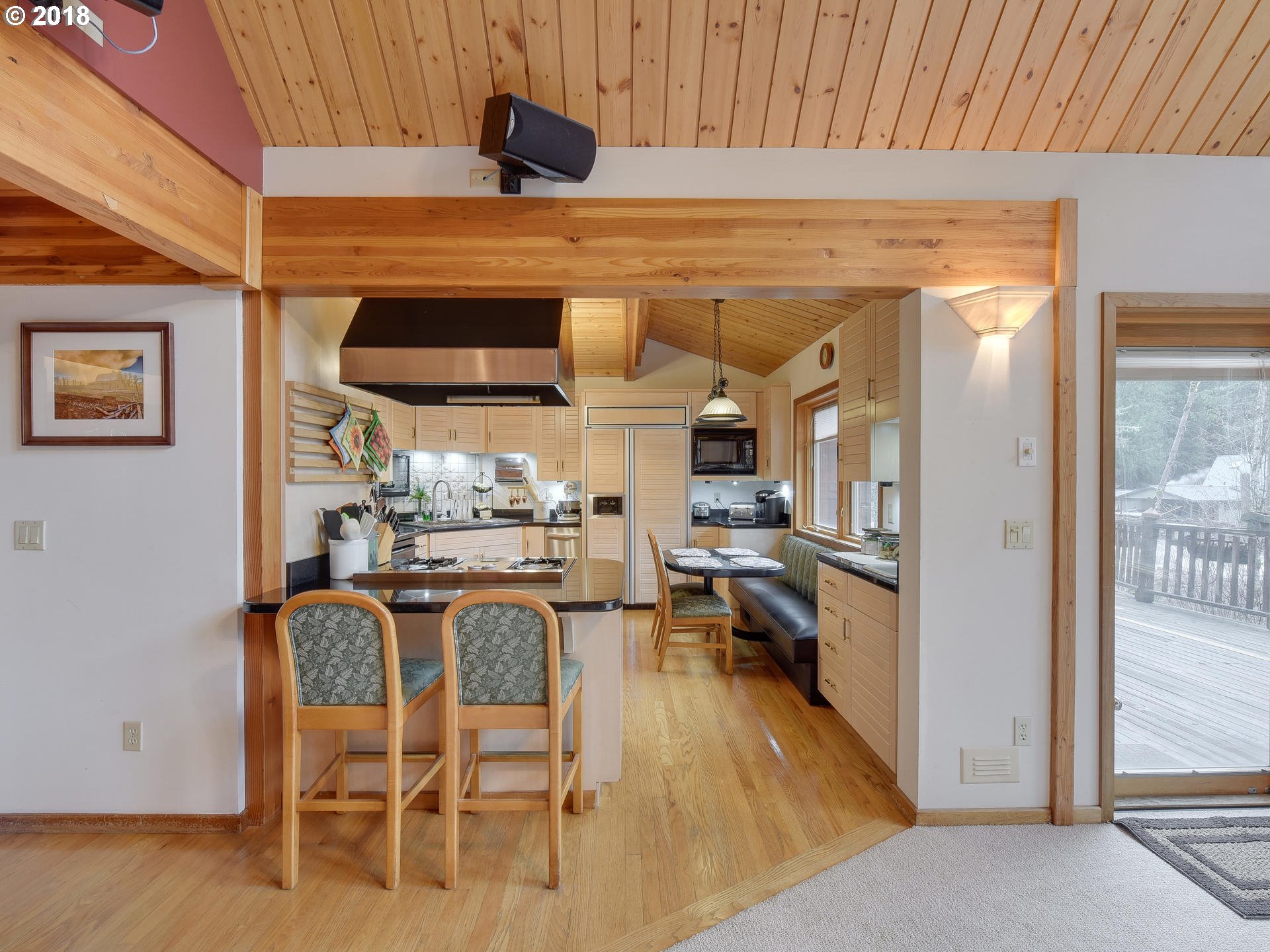 22200 East Lolo Pass Road Rhododendron, OR 97049 - Photo 15 of 32 a kitchen with stainless steel appliances kitchen island granite countertop a table chairs in it and wooden floors