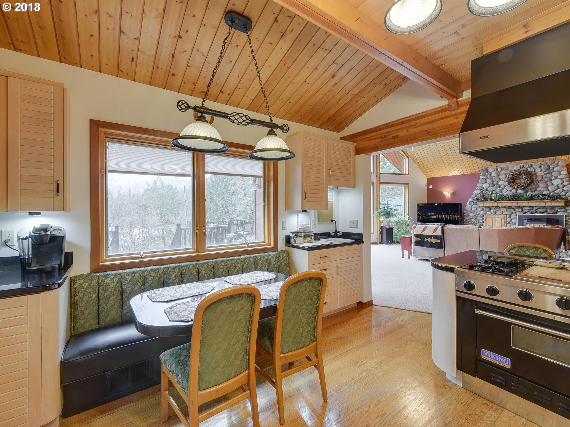 22200 East Lolo Pass Road Rhododendron, OR 97049 - Photo 16 of 32 a kitchen with stainless steel appliances granite countertop a stove a refrigerator a dining table and chairs with wooden floor
