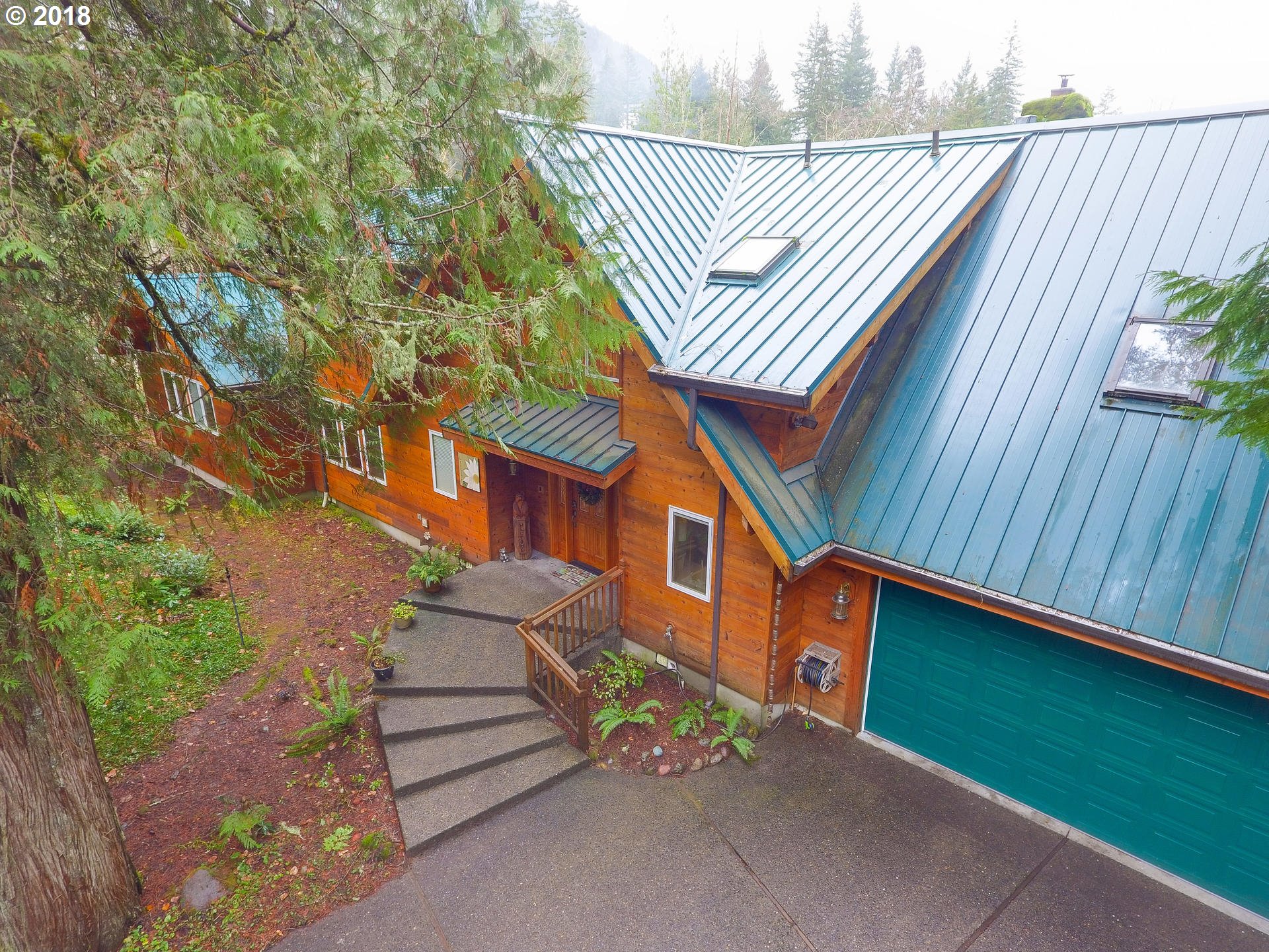 22200 East Lolo Pass Road Rhododendron, OR 97049 - Photo 2 of 32 a front view of a house with a garden