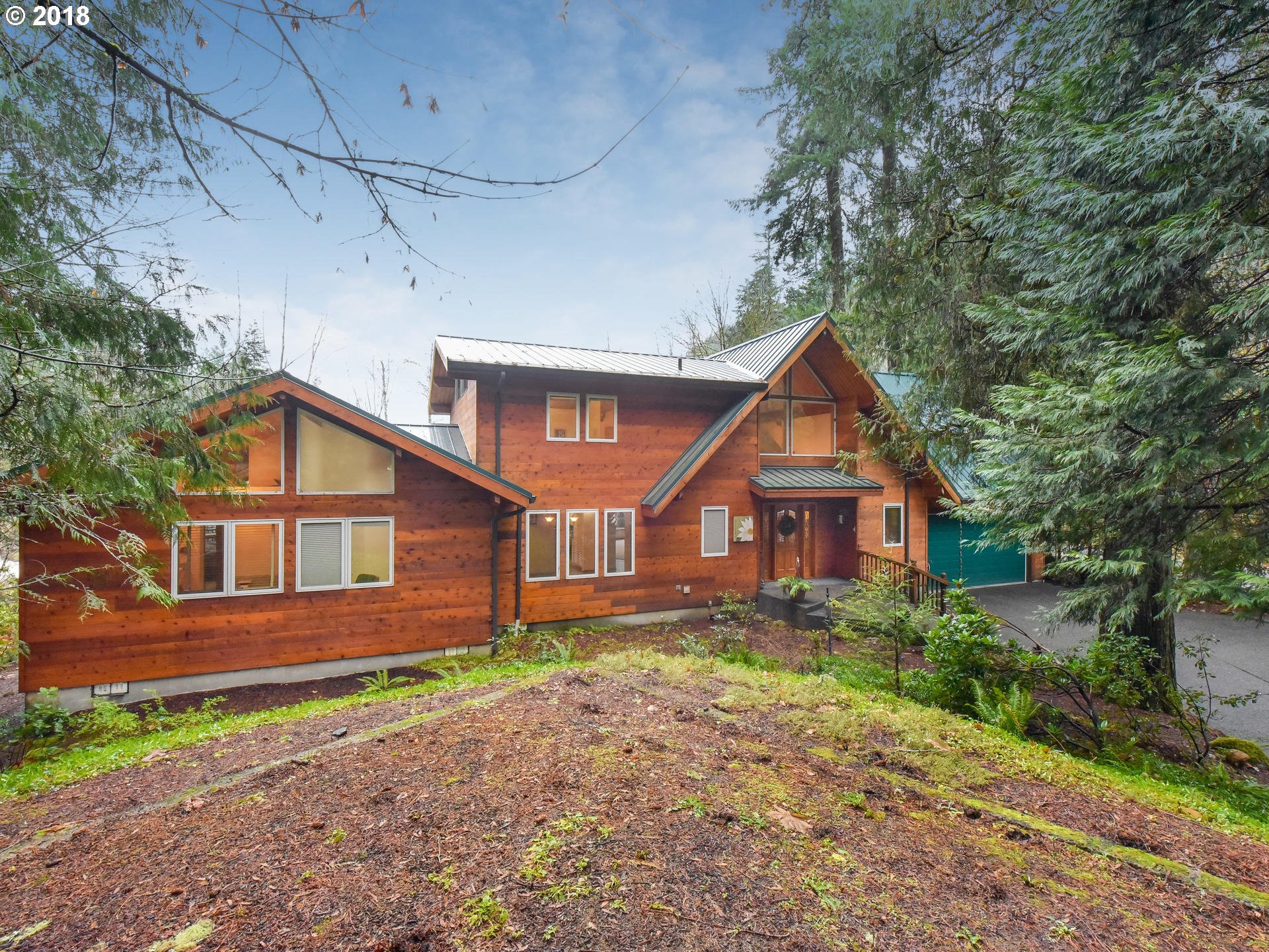 22200 East Lolo Pass Road Rhododendron, OR 97049 - Photo 3 of 32 a front view of a house with a yard and trees