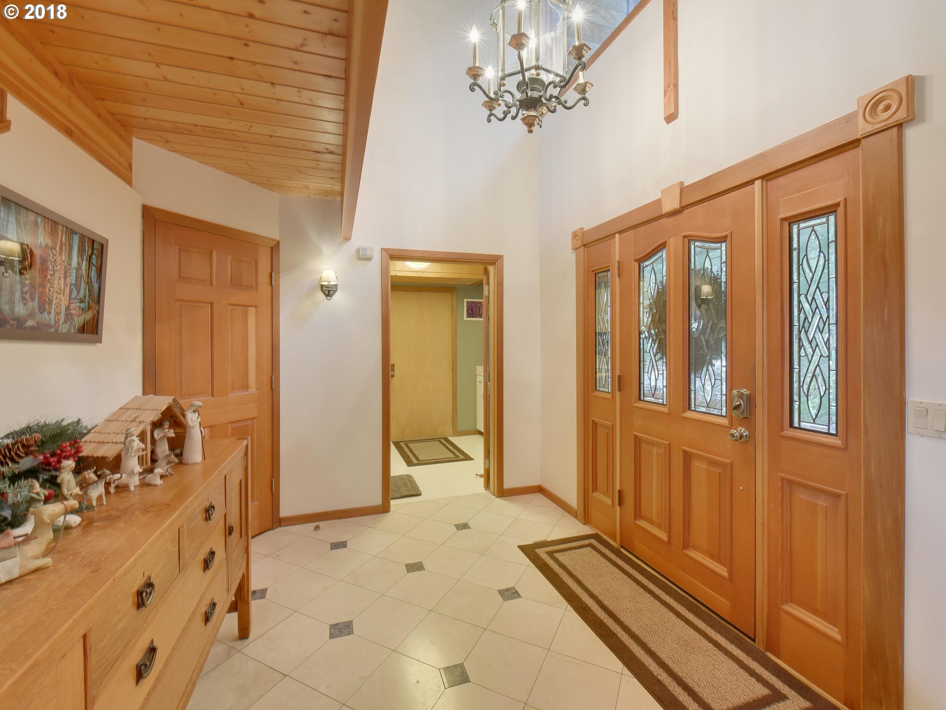 22200 East Lolo Pass Road Rhododendron, OR 97049 - Photo 7 of 32 a view of a bedroom with a bed windows and chandelier