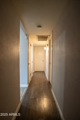 a view of a hallway with wooden floor