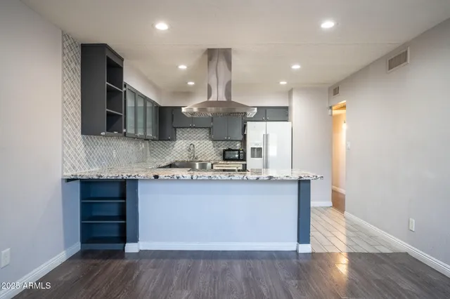 a kitchen with kitchen island a sink and a stove top oven