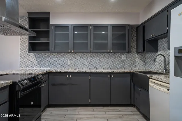 a kitchen with granite countertop a stove and cabinets