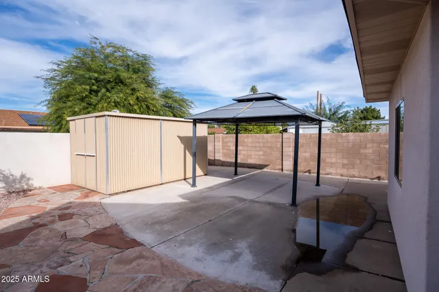 a view of backyard with a patio and fire pit