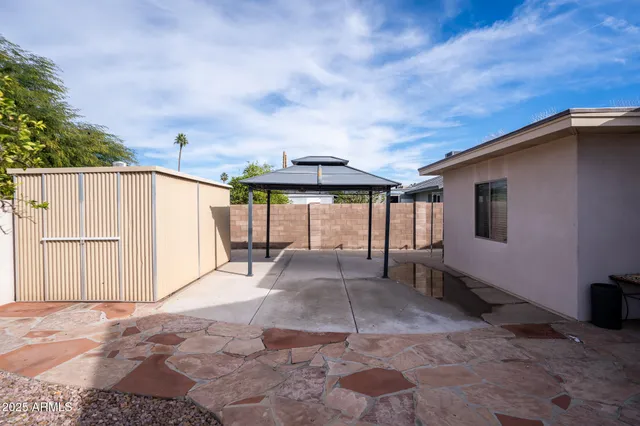 a view of a house with backyard and sitting area