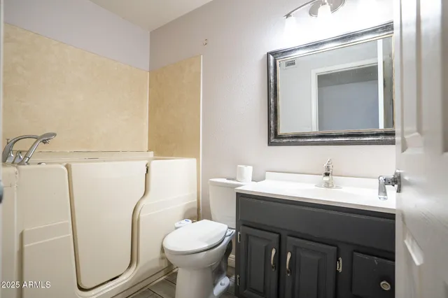 a bathroom with a toilet sink and mirror