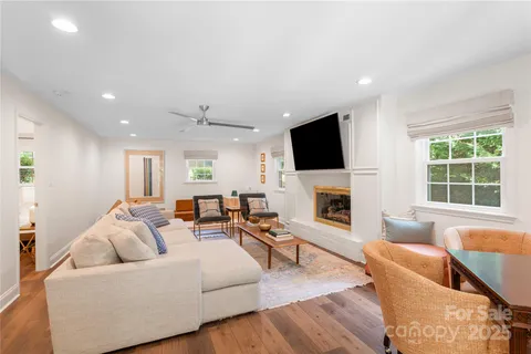 a living room with furniture a fireplace and a flat screen tv
