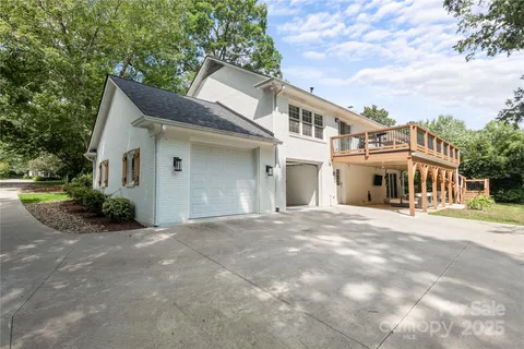 a view of a white house with a yard and plants