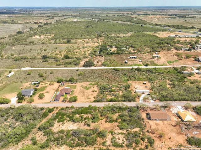 a view of dirt field with lots of bushes