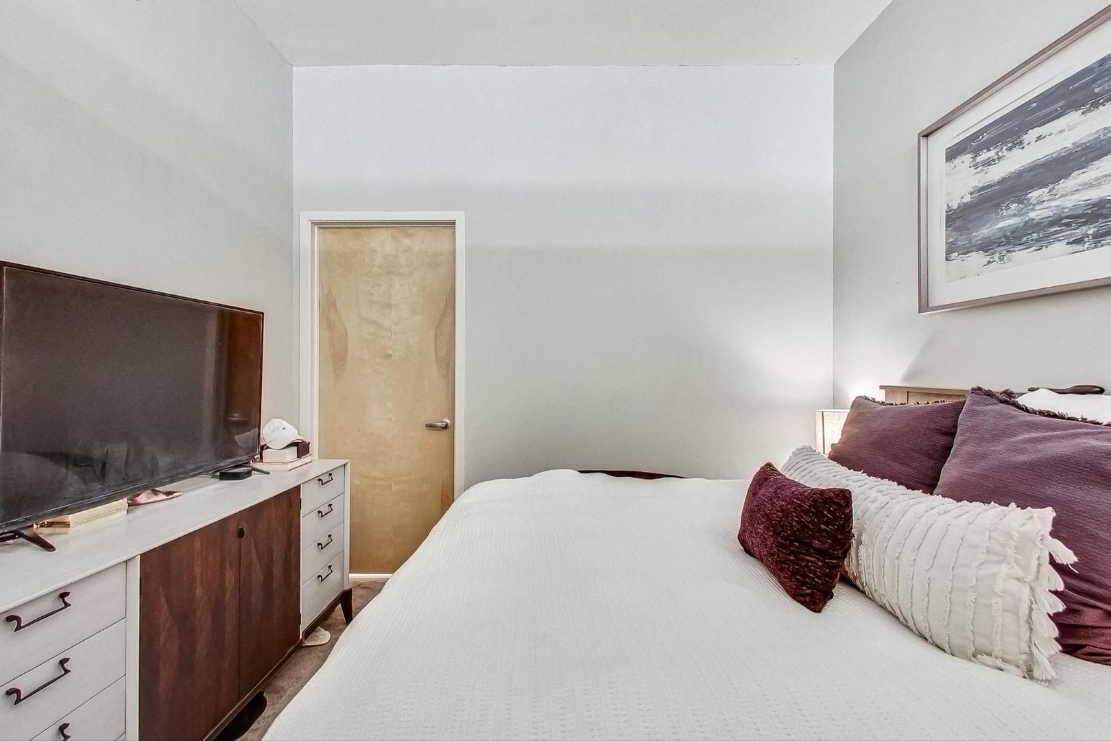 1201 West Adams Street, Unit 609 Chicago, IL 60607 - Photo 11 of 19 a bedroom with a bed and flat screen tv
