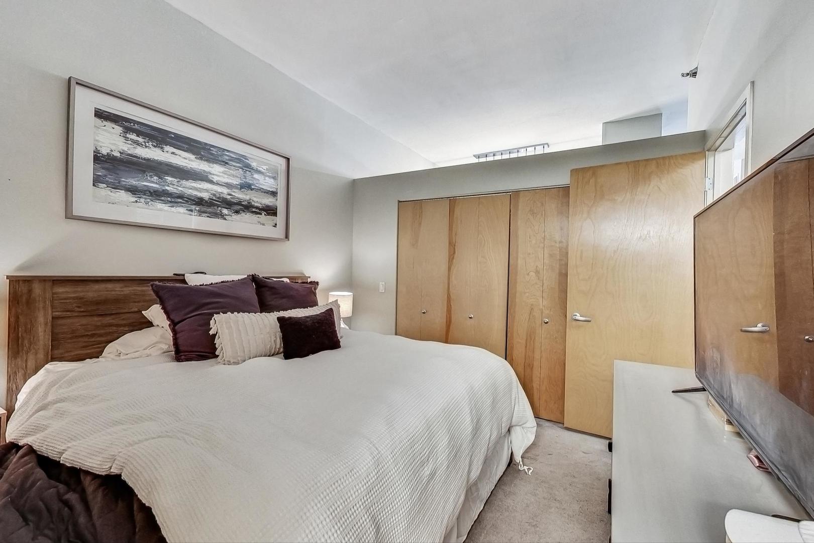 1201 West Adams Street, Unit 609 Chicago, IL 60607 - Photo 12 of 19 a bedroom with a large bed and a shower