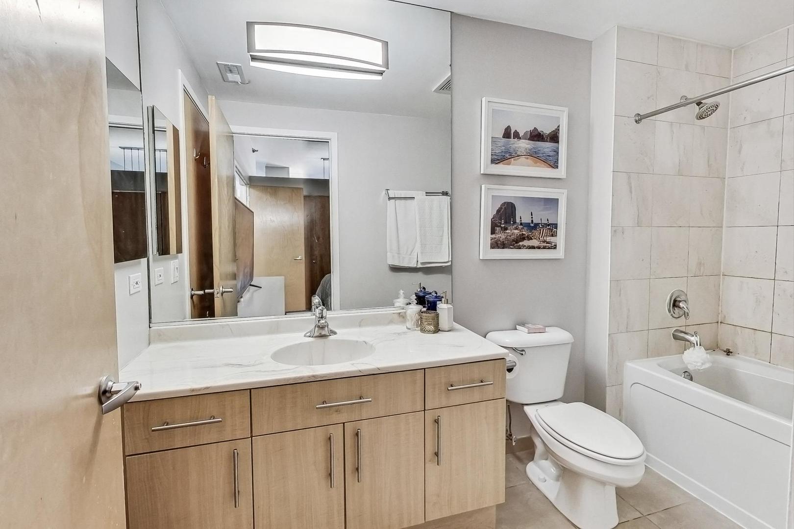 1201 West Adams Street, Unit 609 Chicago, IL 60607 - Photo 13 of 19 a bathroom with a toilet sink and mirror