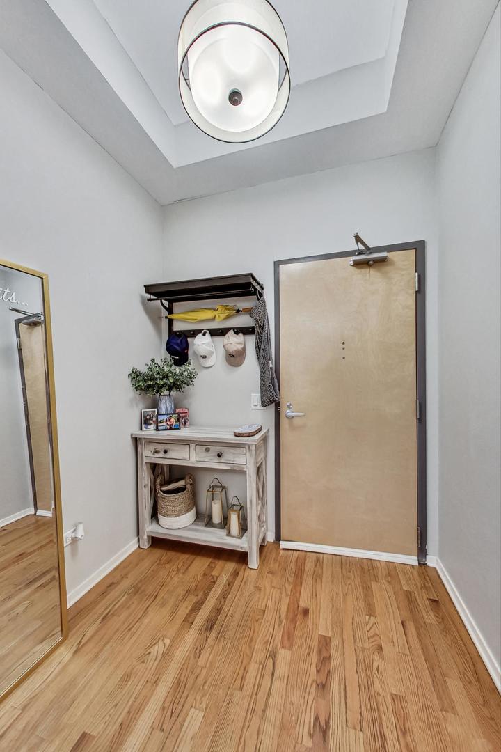 1201 West Adams Street, Unit 609 Chicago, IL 60607 - Photo 3 of 19 an empty room with wooden floor and a fireplace