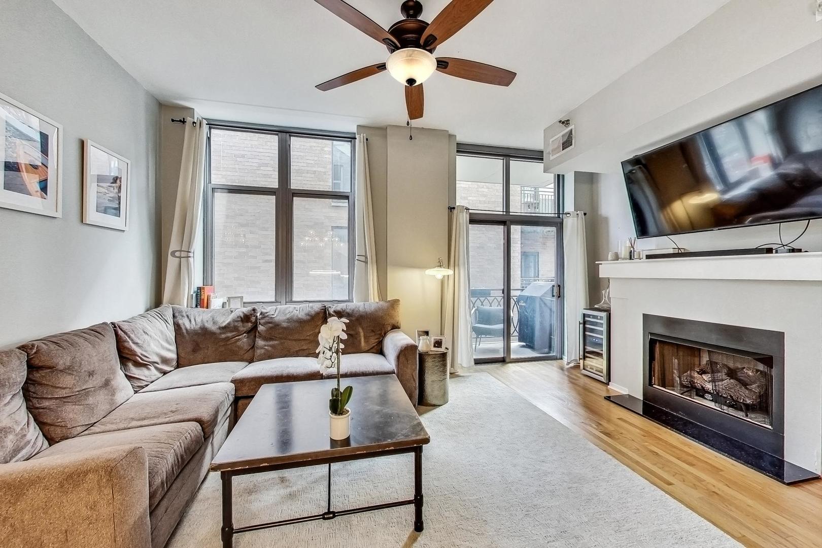 1201 West Adams Street, Unit 609 Chicago, IL 60607 - Photo 5 of 19 a living room with furniture a flat screen tv and a fireplace