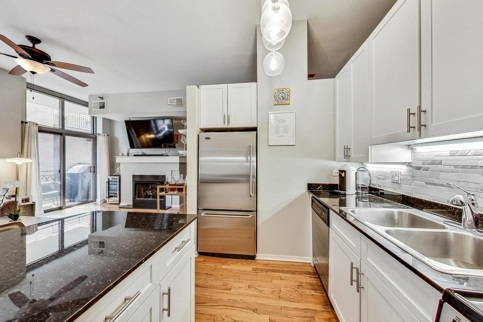 1201 West Adams Street, Unit 609 Chicago, IL 60607 - Photo 10 of 19 a kitchen with granite countertop a sink stove and refrigerator