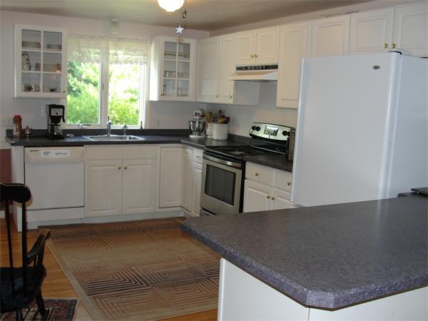 1135 Service Road Barnstable, MA 02668 - Photo 14 of 15 a kitchen with granite countertop a stove a sink and a refrigerator