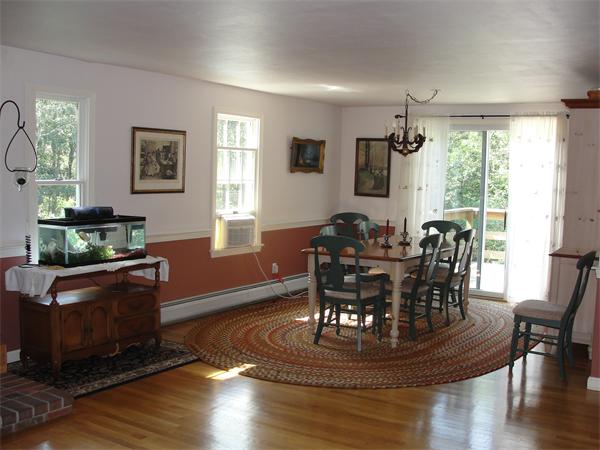 1135 Service Road Barnstable, MA 02668 - Photo 9 of 15 a dining room with wooden floor a chandelier a glass table and chairs