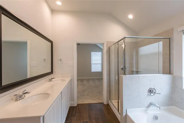 a bathroom with a tub sink and mirror