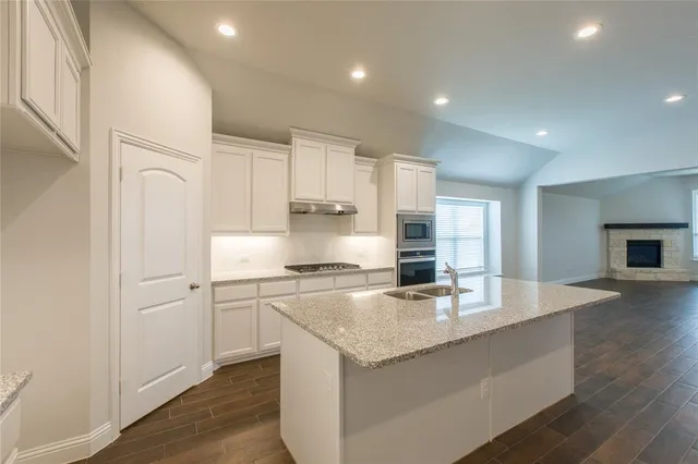a kitchen with granite countertop white cabinets and white appliances