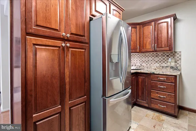 a kitchen with stainless steel appliances granite countertop a refrigerator a stove and a sink