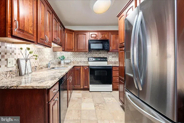 a kitchen with stainless steel appliances granite countertop a refrigerator stove and sink