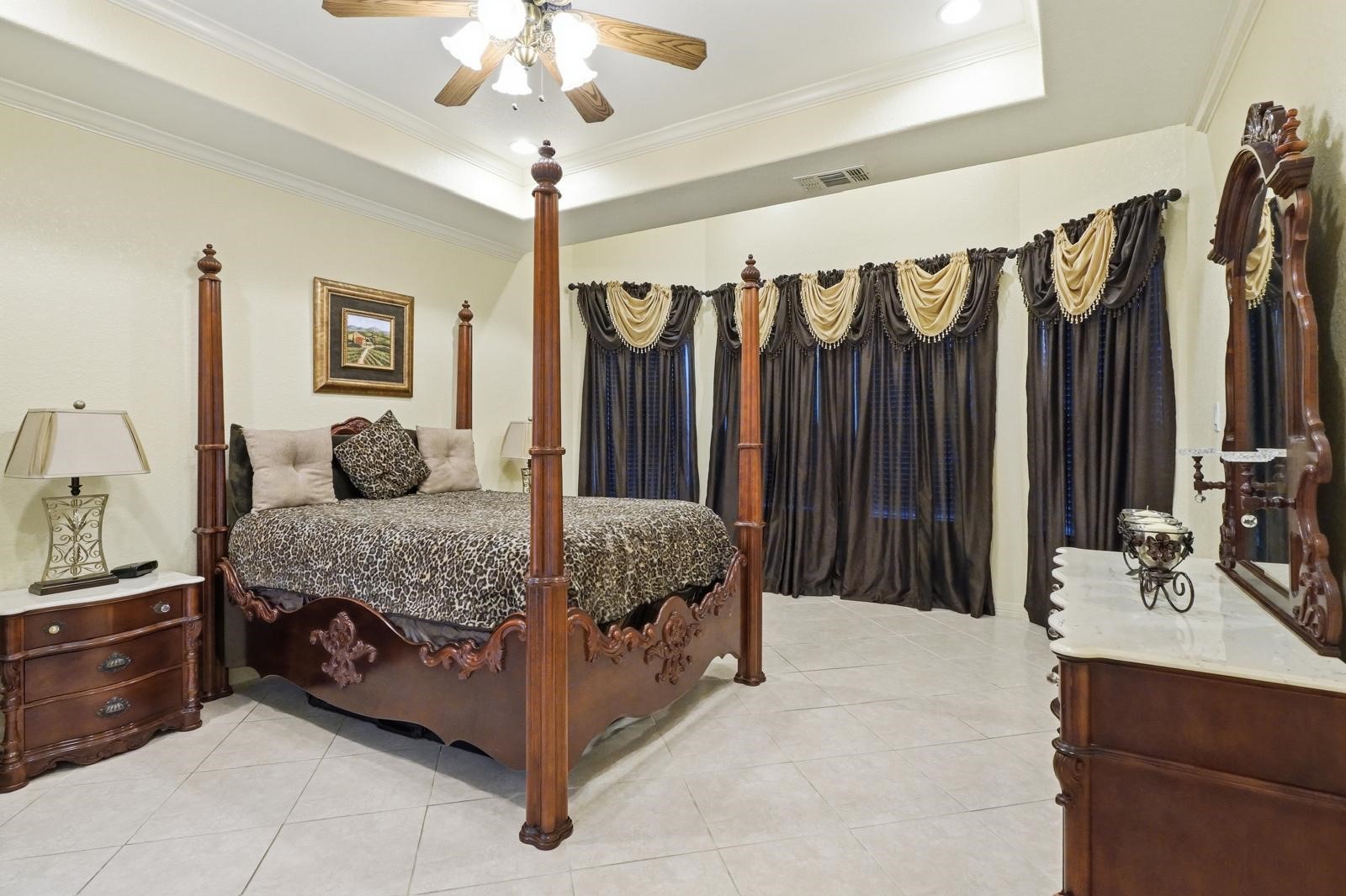 247 Old Spring Lane Houston, TX 77015 - Photo 13 of 25 a bedroom with a large bed and a chandelier