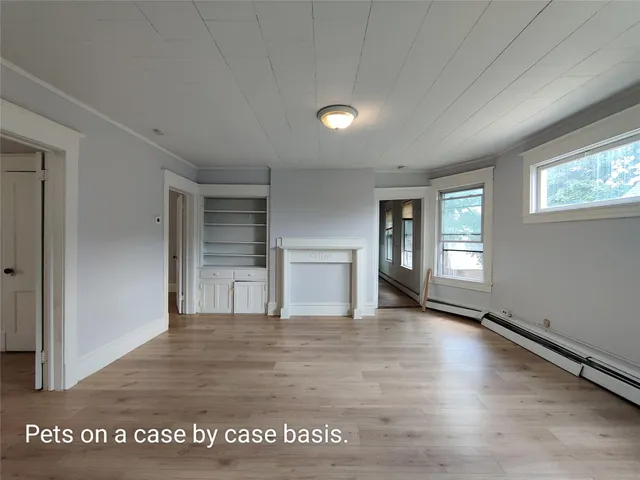a view of a big room with wooden floor and windows